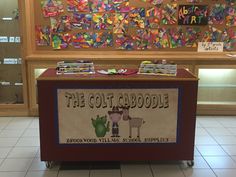 a display case in the middle of a room filled with children's books and crafts