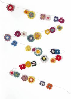 the garden garland is made with crochet flowers and yarn, which are multicolored