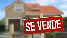 a red and white sign that says se vende on it in front of a house