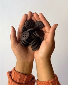 a person holding up buttons in their hands