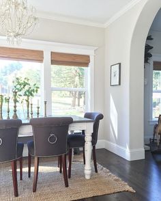 a dining room table with four chairs and a chandelier