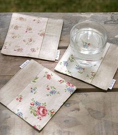 three napkins and a glass on a wooden table