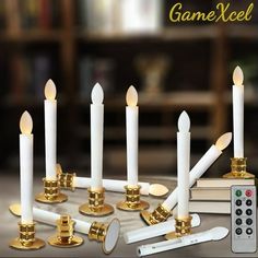 there are many white candles with gold trims and remote controls in front of them