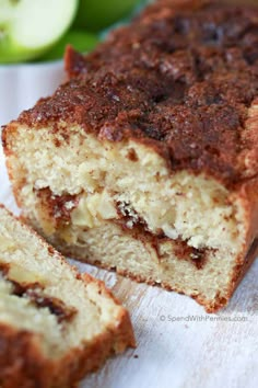 two pieces of cake sitting next to each other on a white napkin with an apple in the background