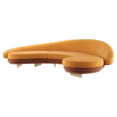 an orange curved couch sitting on top of a white floor