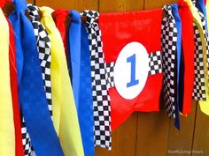 a number one banner hanging from a wooden wall with ribbons attached to it's sides