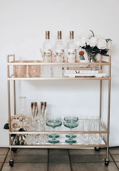 a bar cart filled with glasses and bottles