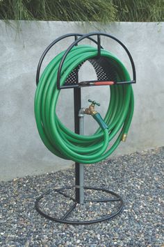 a green hose is attached to a black stand