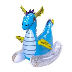 an inflatable blue and yellow dragon sitting on top of a white object with gold sprinkles