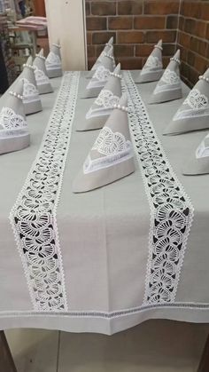 the table is covered with white linens and has lace on it's edges