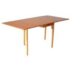 a wooden table with two legs and a small drawer on the bottom one is empty