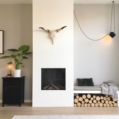 a living room with white walls and wood logs