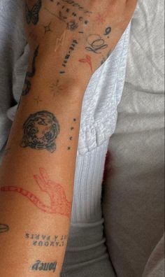 a woman with tattoos on her arm holding a cell phone