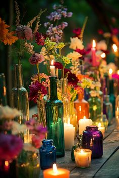 there are many vases with flowers and candles on the table next to each other