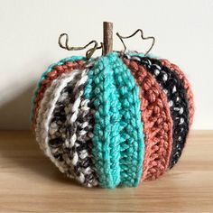 a crocheted pumpkin sitting on top of a wooden table