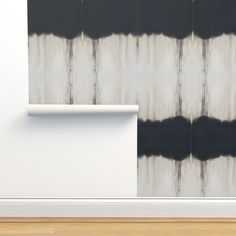 an abstract painting with black and white stripes on the wall next to a wooden floor