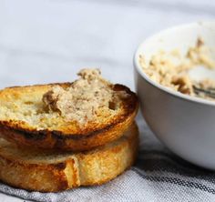 two pieces of bread sitting next to a bowl of food