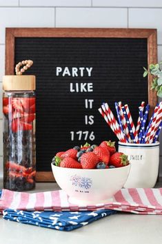 strawberries and blueberries are in a bowl next to a sign that says party like it is 1876