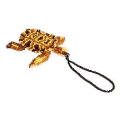 a beaded turtle keychain is shown on a white background with a black lanyard