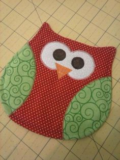 an owl is sitting on top of a piece of fabric