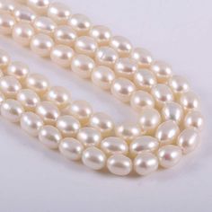 three strands of white pearls on a white background