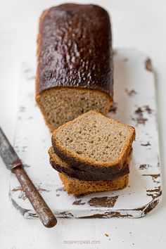 a loaf of bread sitting on top of a white cutting board next to a knife