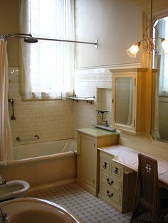 a bathroom with a sink, mirror and bathtub next to a window in it