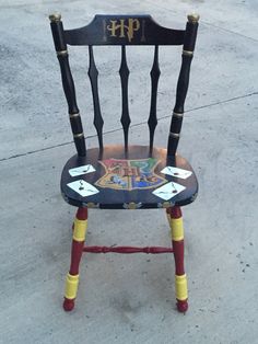 a chair that has been painted with letters and numbers on the back, sitting in front of a sidewalk