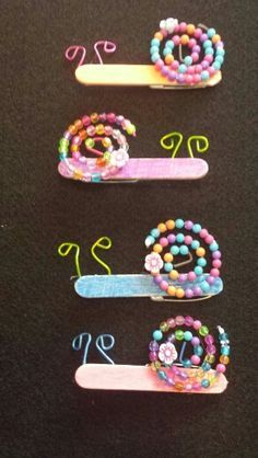 four different colored hair clips with beads on them and numbers written in the same language