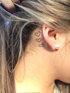 a woman with a heart tattoo behind her ear