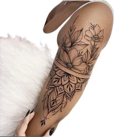 a woman's leg with tattoos on it and flowers in the middle of her legs