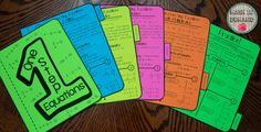 five colorful notebooks with writing on them sitting on a wooden table next to an apple