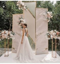 a woman standing in front of a mirror wearing a wedding dress with flowers on it