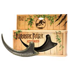 an animal's tooth is shown in front of a wooden box with the word dinosaur park on it