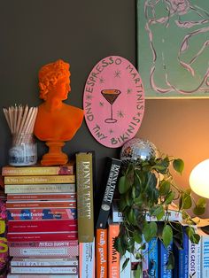 a shelf filled with books and vases next to a lamp on top of a table