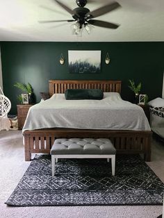 a bed room with a neatly made bed and a ceiling fan in it's corner