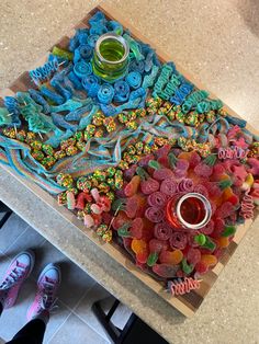 a table topped with lots of different colored candies and cupcakes on top of it