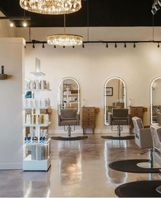 a salon with lots of chairs and chandeliers