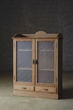 a wooden cabinet with two glass doors on the front and bottom, against a dark background