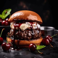 a cheeseburger with cherries on the side and sauce drizzled over it