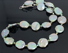 This glowing 17.25 inch long Coin Pearl necklace set with a silver tone clasp is enhanced with little Czech crystal sparkles. Depending on what light you are in the pearls glow many colors of silver or blue or green or pinkish reflections. The Pearls are approximately 17 mm. This is a happy necklace. Elegant Iridescent Necklace With Round Beads, Iridescent Pearl Jewelry With Pearl Drop, Elegant Iridescent Round Bead Necklaces, Elegant Iridescent Beaded Necklace, Elegant Adjustable Iridescent Necklaces, Elegant Iridescent Adjustable Necklace, Elegant Handmade Iridescent Beaded Necklaces, Elegant Iridescent Adjustable Necklaces, Elegant Iridescent Beaded Jewelry