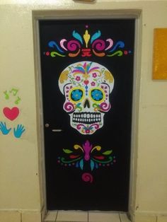 a door decorated with colorful sugar skulls and hand prints