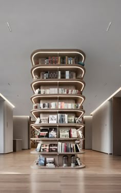 a large book shelf filled with lots of books on top of a hard wood floor