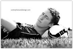 a young man laying in the grass with a soccer ball