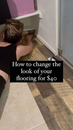 a woman laying on the floor in front of a toilet with her legs up and head down