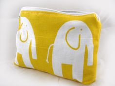 a yellow and white elephant pouch with two elephants on the front, one has its trunk in the other's pocket