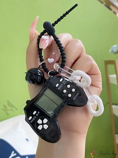 a hand holding an electronic device with beads and ear buds attached to it's wrist