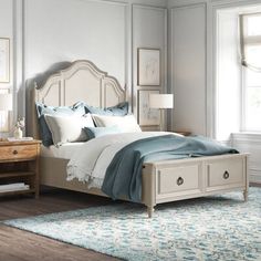 a white bed sitting in a bedroom on top of a wooden floor