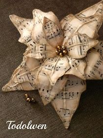 an ornament made out of sheet music with bells on it's side