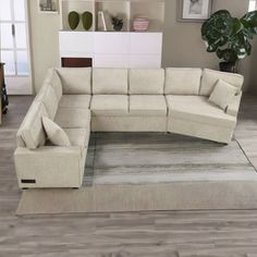 a large sectional couch sitting on top of a rug in front of a white wall